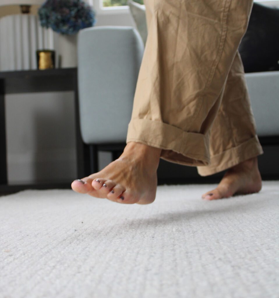 Homeowner enjoying soft clean carpet after professional steam cleaning service